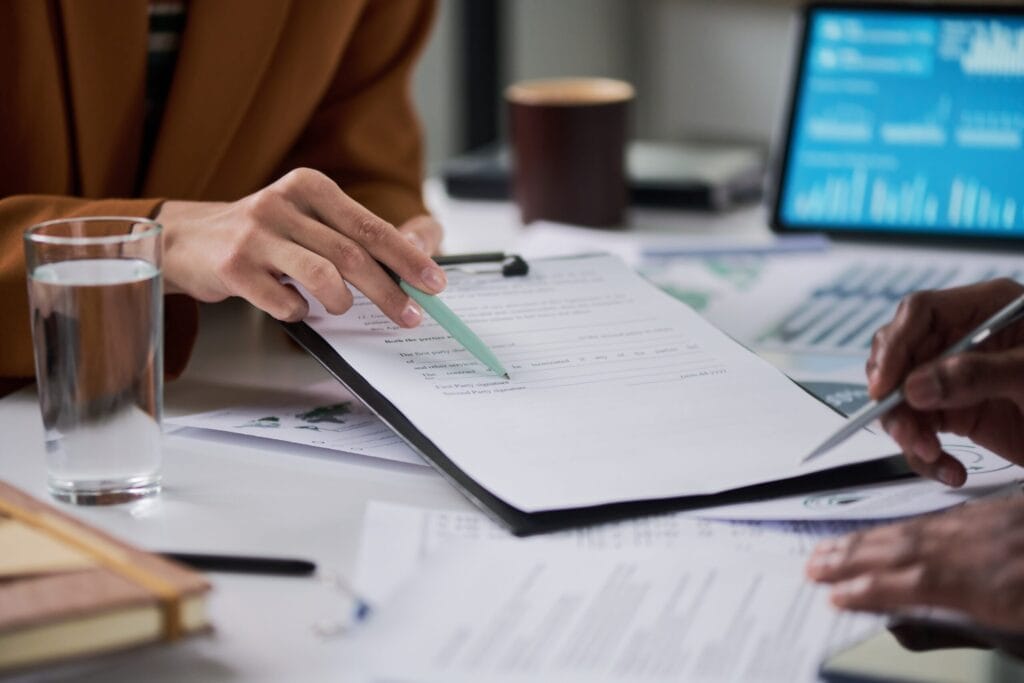 how to rebuild records after a natural disaster - Caucasian woman and Black man collaborating on paperwork at a desk, discuss
